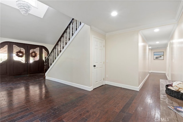 foyer entrance featuring ornamental molding, a notable chandelier, french doors, and dark hardwood / wood-style floors