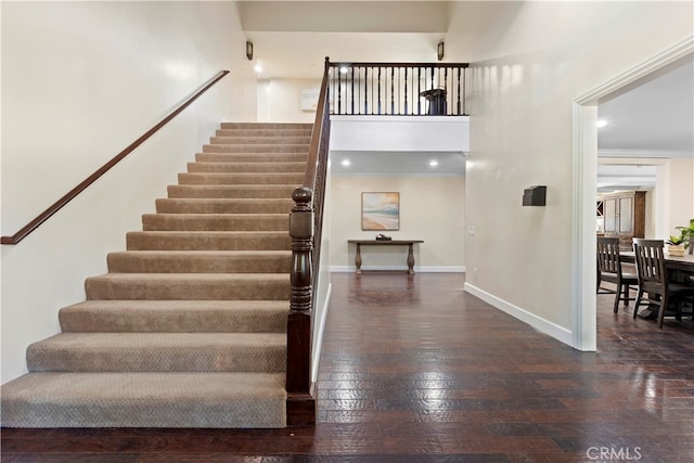 staircase featuring crown molding and hardwood / wood-style floors