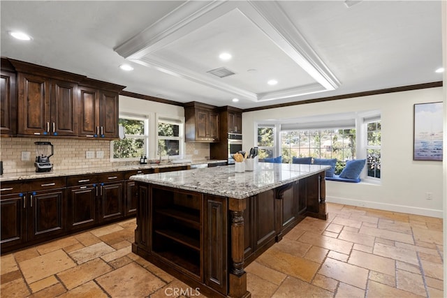 kitchen featuring a kitchen island, plenty of natural light, dark brown cabinetry, and tasteful backsplash