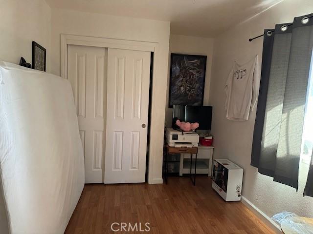 bedroom featuring hardwood / wood-style flooring, heating unit, and a closet