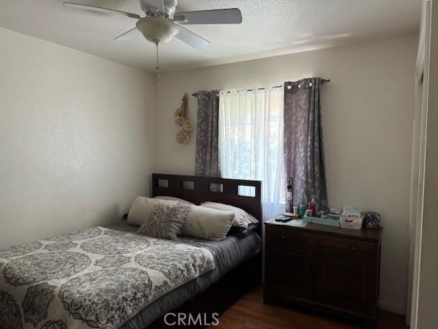 bedroom with ceiling fan and dark hardwood / wood-style flooring