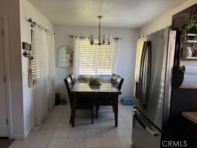 tiled dining space featuring a notable chandelier