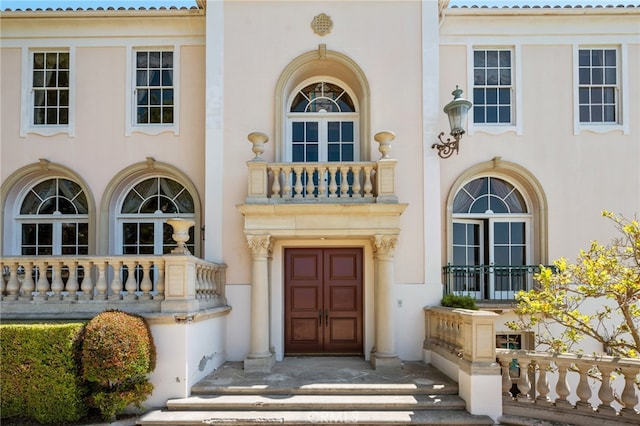 property entrance with a balcony and french doors