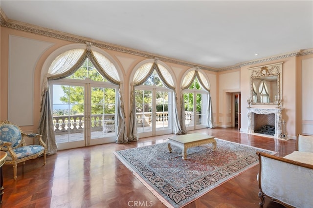 living room with a premium fireplace, parquet floors, and crown molding