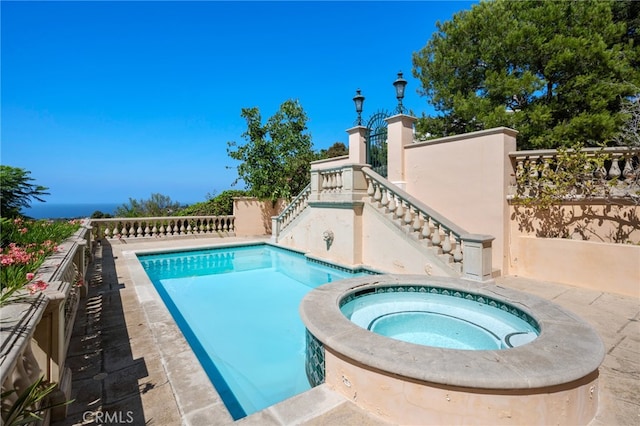 view of swimming pool featuring an in ground hot tub