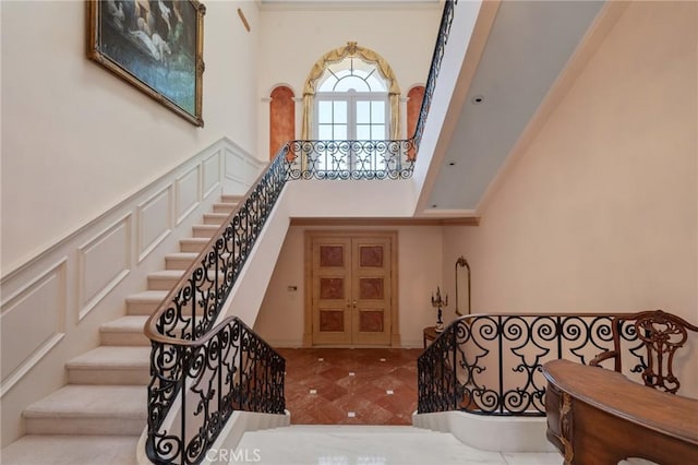 2736 Via Victoria, Palos Verdes Estates, CA 90274 - foyer featuring a decorative wall, a high ceiling, stairway, and wainscoting
