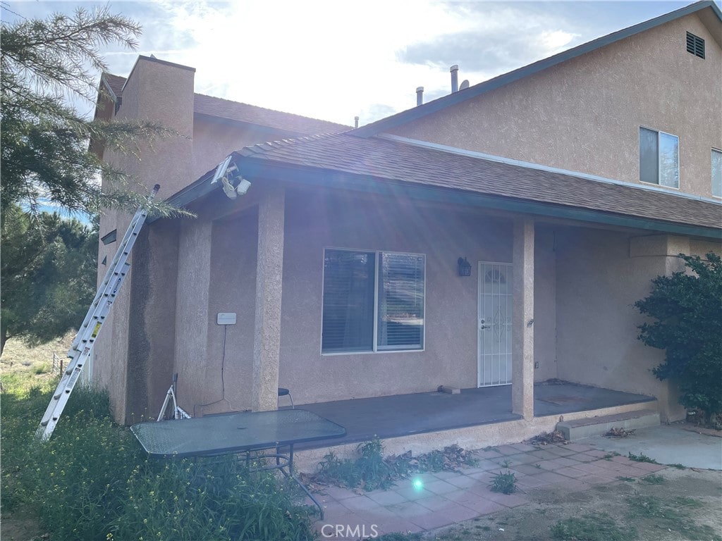 rear view of house featuring covered porch