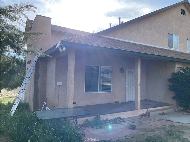 rear view of house featuring covered porch