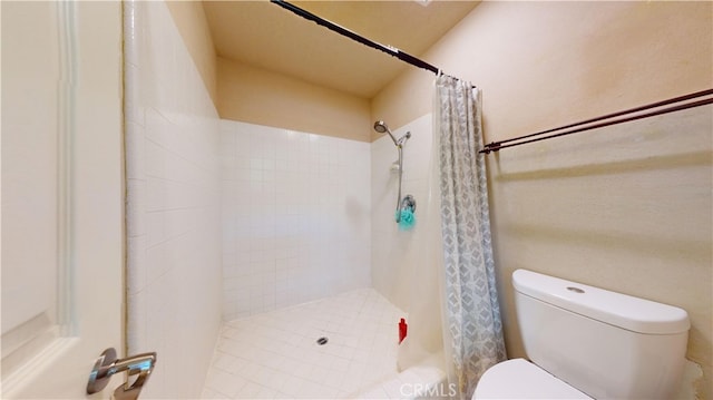 bathroom with toilet and a shower with shower curtain