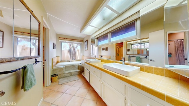 bathroom with tile patterned floors, a bath, vanity, and tasteful backsplash