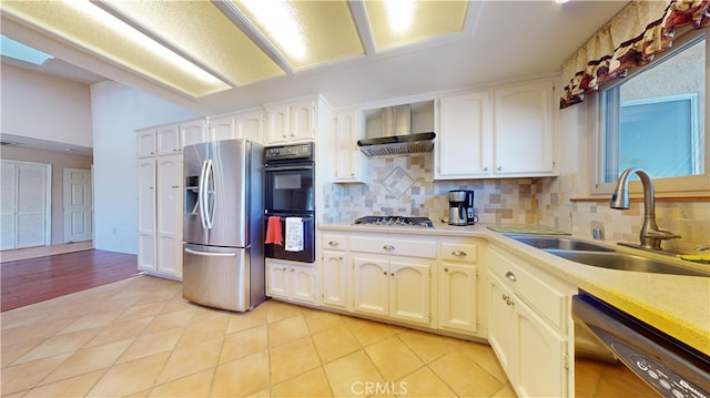 kitchen with appliances with stainless steel finishes, wall chimney range hood, tasteful backsplash, and sink