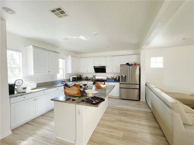 kitchen with appliances with stainless steel finishes, light hardwood / wood-style floors, a kitchen island, and white cabinets