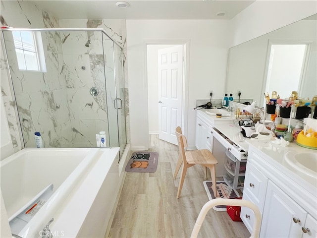 bathroom with vanity, hardwood / wood-style floors, and separate shower and tub