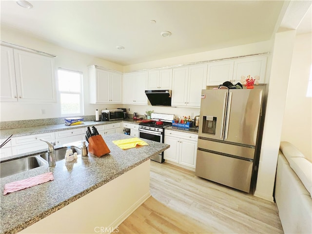 kitchen featuring appliances with stainless steel finishes, white cabinetry, light stone counters, light hardwood / wood-style flooring, and sink