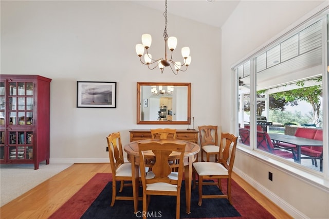 dining area with a notable chandelier, lofted ceiling, and hardwood / wood-style flooring