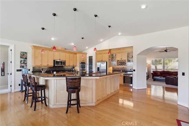 kitchen featuring stainless steel appliances, light hardwood / wood-style floors, ceiling fan, and light brown cabinetry