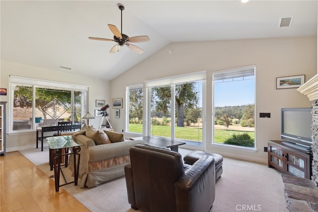 living room with ceiling fan, light hardwood / wood-style flooring, vaulted ceiling, and a wealth of natural light