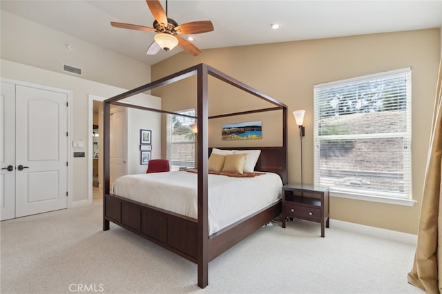 carpeted bedroom with multiple windows, vaulted ceiling, ceiling fan, and a closet