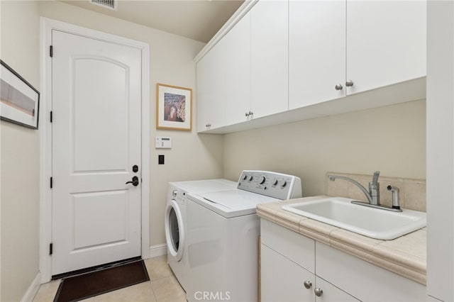 washroom featuring cabinets, light tile patterned floors, washer and clothes dryer, and sink