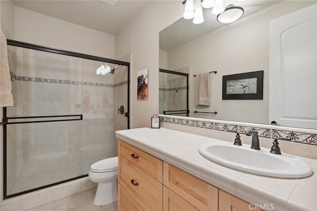 bathroom featuring tile patterned floors, an enclosed shower, vanity, and toilet