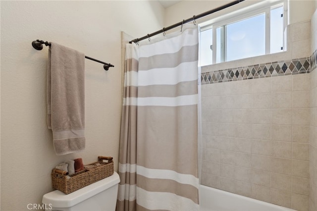 bathroom featuring shower / bath combination with curtain and toilet