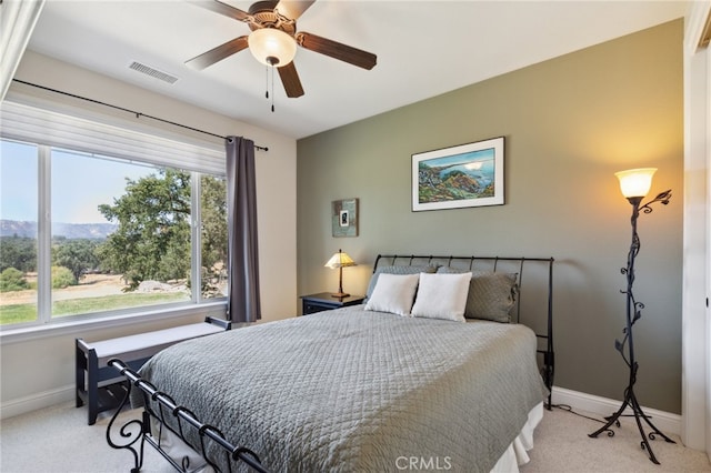 bedroom with ceiling fan, light carpet, and multiple windows