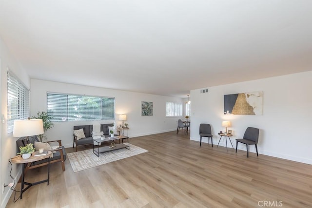 living room with a healthy amount of sunlight and light hardwood / wood-style flooring