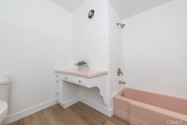 bathroom featuring hardwood / wood-style flooring, toilet, lofted ceiling, and shower / bathing tub combination