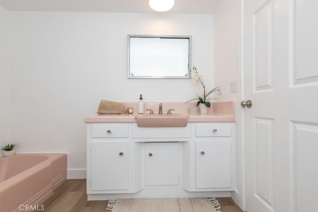 bathroom with a bathtub, hardwood / wood-style floors, and vanity