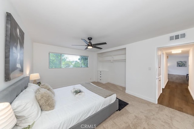 carpeted bedroom with ceiling fan and a closet