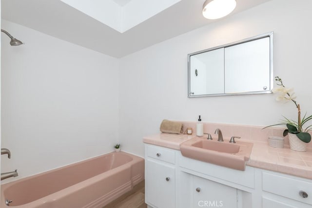 bathroom featuring vanity and a tub to relax in