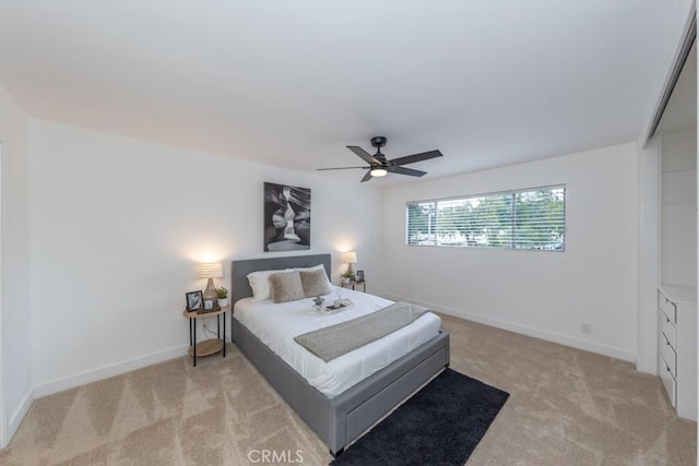 bedroom featuring ceiling fan, light carpet, and a closet