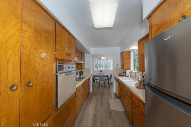 kitchen with light hardwood / wood-style flooring, stainless steel appliances, and sink