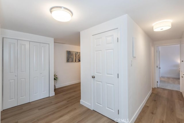 corridor with light hardwood / wood-style floors