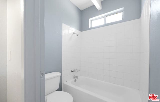 bathroom with toilet and tiled shower / bath