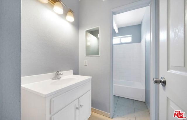 bathroom featuring tile patterned floors, vanity, and a washtub