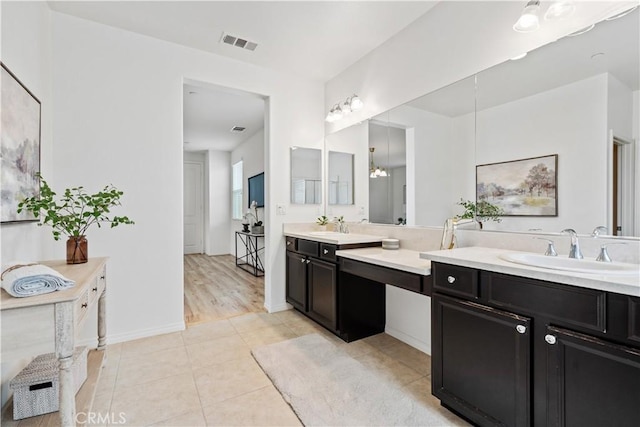 bathroom with hardwood / wood-style flooring, vanity, and a chandelier