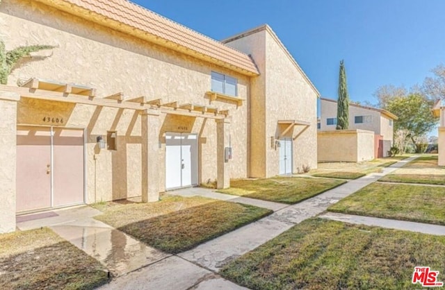 view of front of property with a pergola and a front lawn