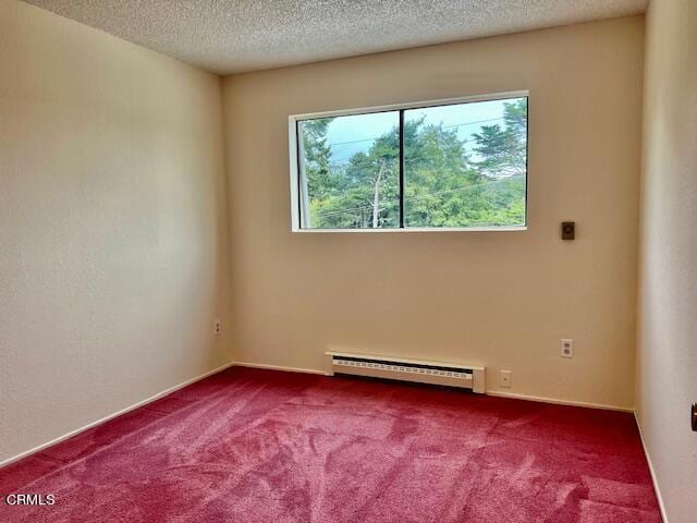 carpeted spare room with a textured ceiling and a baseboard heating unit