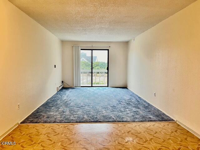 empty room featuring a textured ceiling and baseboard heating