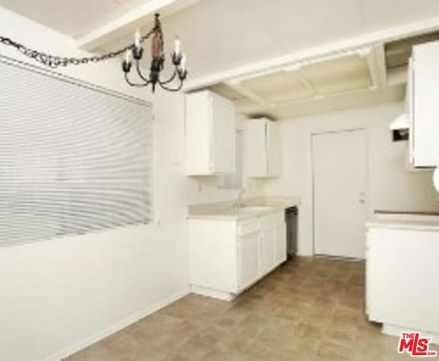 kitchen featuring white cabinetry, sink, and an inviting chandelier