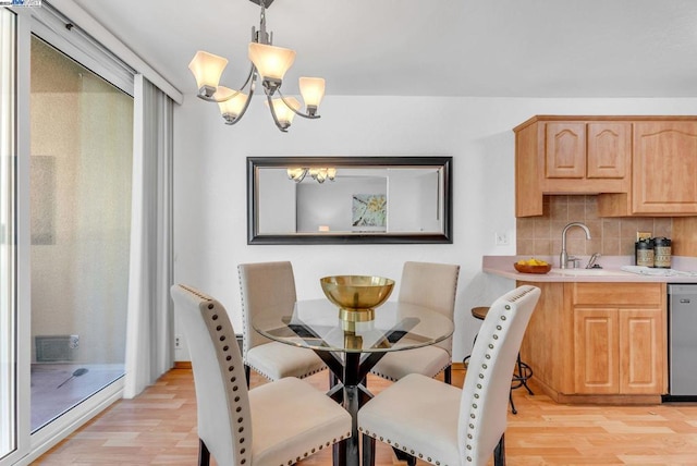 dining area featuring light hardwood / wood-style flooring, a chandelier, and sink