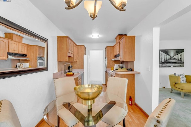 kitchen with sink, white appliances, and light wood-type flooring