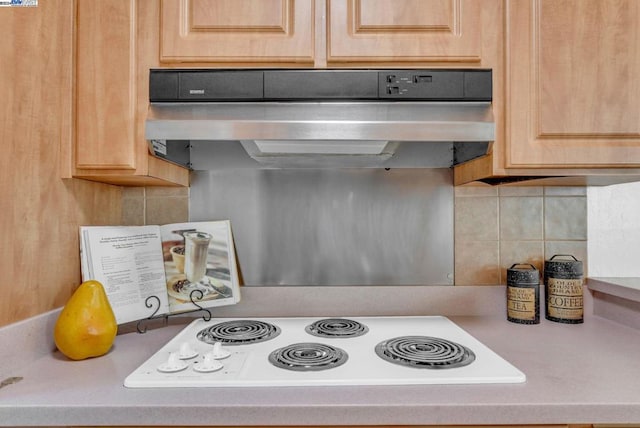 kitchen with decorative backsplash, light brown cabinets, white electric stovetop, and exhaust hood