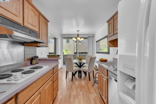 kitchen featuring backsplash, white appliances, pendant lighting, a chandelier, and light hardwood / wood-style floors