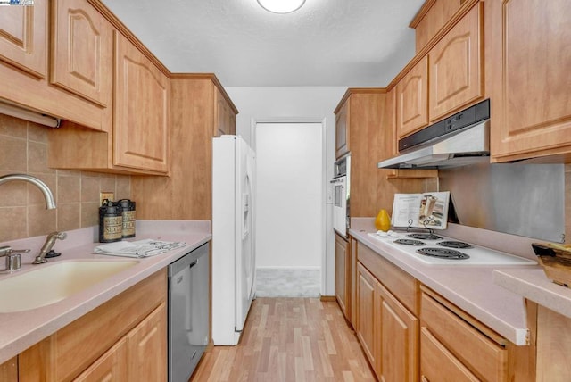 kitchen with light wood-type flooring, backsplash, white appliances, sink, and light brown cabinets