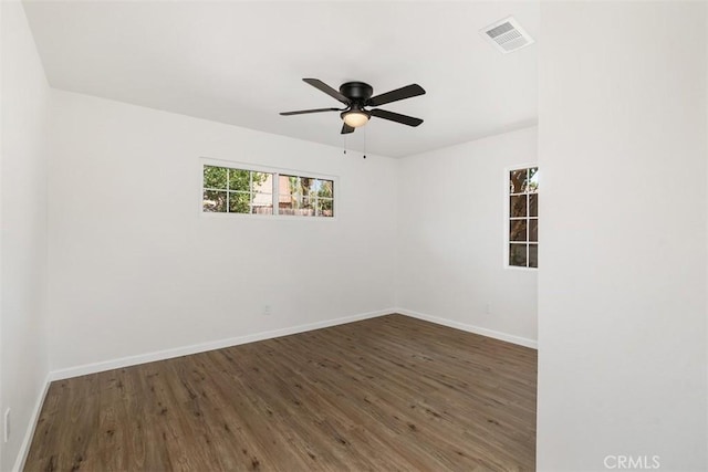 spare room with dark hardwood / wood-style floors and ceiling fan