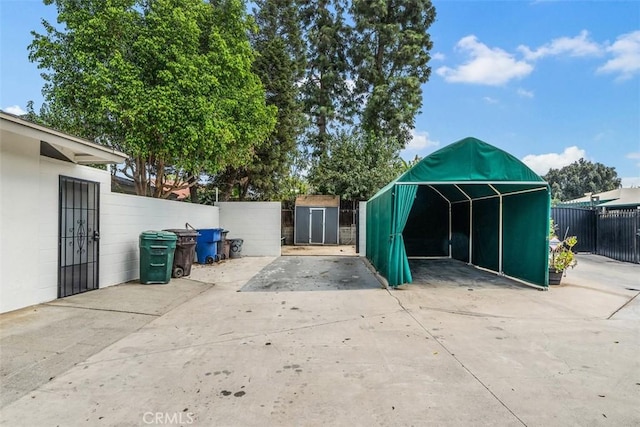 view of patio with a carport and a shed