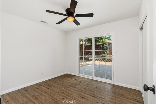 spare room featuring ceiling fan and dark wood-type flooring