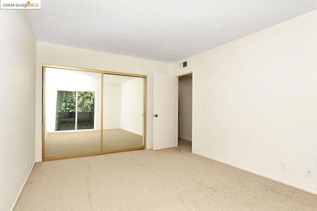 unfurnished bedroom with carpet floors and a closet